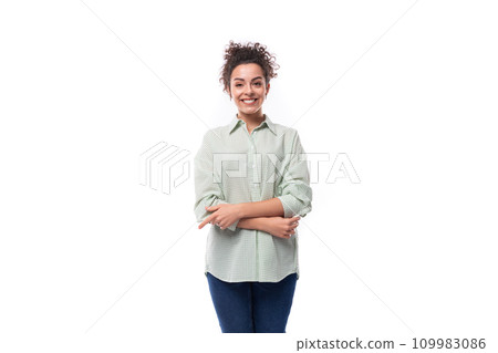 young cute caucasian brunette woman with curly hair dressed in an oversized shirt smiles at the 109983086