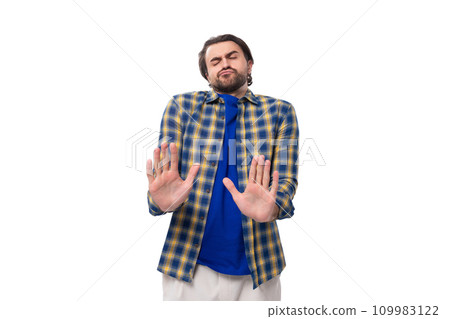 young caucasian brunette man with a beard and an earring is dressed in a blue plaid shirt and t 109983122