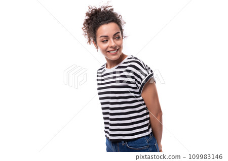 young caucasian woman with curly black hair dressed in a striped black and white t-shirt looks happy 109983146
