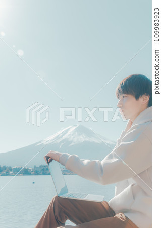 Young man using a computer at Lake Yamanaka 109983923