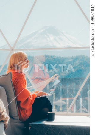 Caucasian woman looking at a computer on the observation deck Caucasian woman looking at a computer on the observation deck 109984014