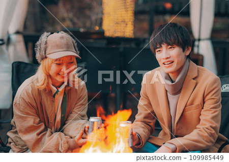 Couple toasting over a bonfire at a campsite Couple toasting over a bonfire at a campsite 109985449