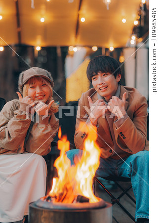 一對夫婦在露營地的營火旁舉杯 109985485
