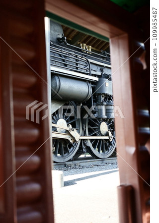 Steam locomotive peeking through a small window 109985487