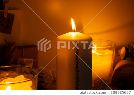 Candle with advent calendar Traditional Burning Christmas Wax Candles with numbers counting down for Christmas. Beautiful Advent At Home. Festive Candlelight And Dark Background 109985697