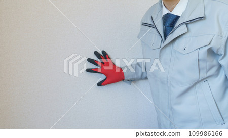 Man in work clothes inspecting wallpaper | Renovation survey/estimate image Man in work clothes inspecting wallpaper | Renovation survey/estimate image 109986166