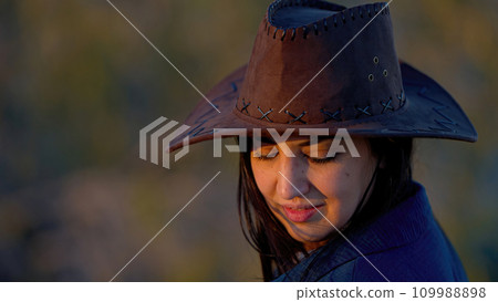 Portrait shot of a young cowgirl wearing a cowboy hat posing for the camera 109988898