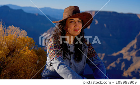 Young woman enjoying the incredibly impressive view over the majestic Grand Canyon 109988909