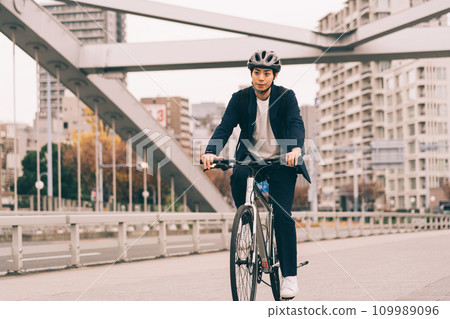 A businessman riding a bicycle A businessman riding a bicycle 109989096