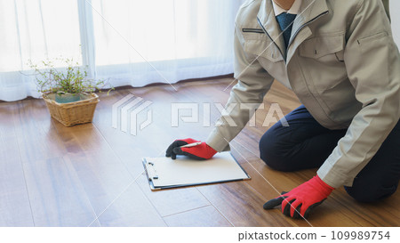 A man in work clothes checking and inspecting the flooring A man in work clothes checking and inspecting the flooring 109989754