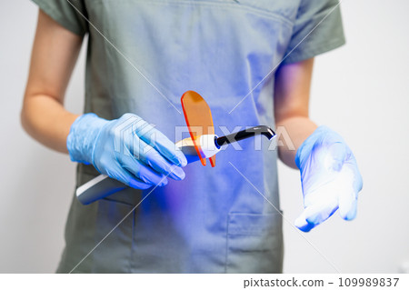 UV lamp in dentists hand in rubber gloves 109989837