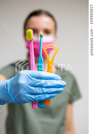 Dentist holding different toothbrushes in dentist hand Dentist holding different toothbrushes in dentist hand 109989857