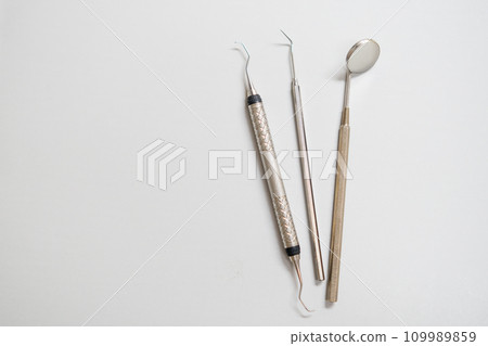 Dental tools, mirror, explorer, hook on the white background with copy space. Dental tools, mirror, explorer, hook on the white background with copy space. 109989859