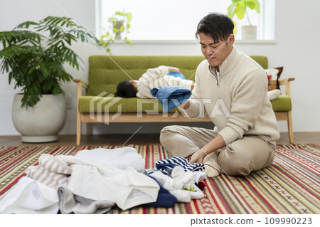 一個 30 多歲的男人疊衣服——父母和孩子的日常形象 109990223
