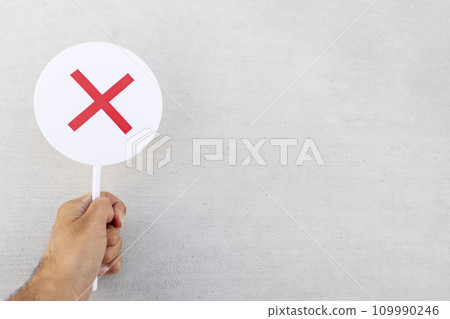 A man's hand holding a plate of hardened concrete and a cross 109990246