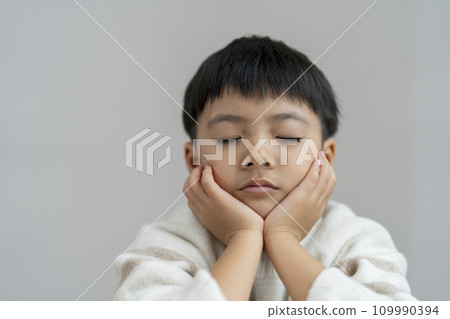A boy thinking with his eyes closed 109990394