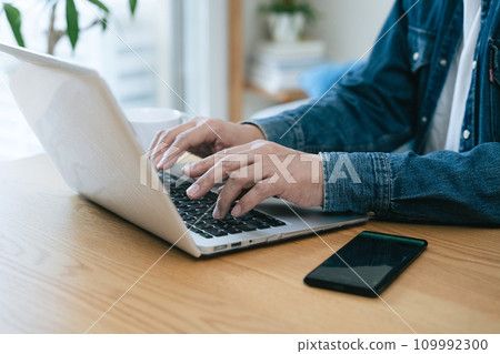 Middle-aged man operating a computer at home 109992300