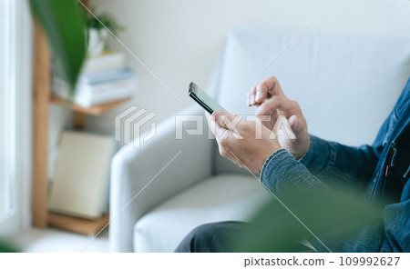 在家操作智慧型手機的中年男子 109992627