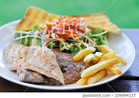 pork steak and chicken steak with French fries ,bread and salad or grilled pork and grilled chicken with fried potato 109994137