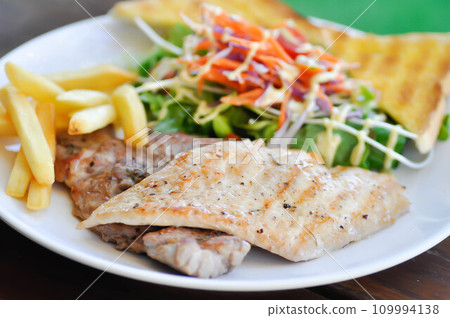 pork steak and chicken steak with French fries ,bread and salad or grilled pork and grilled chicken with fried potato 109994138