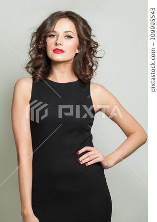 Stylish woman. Portrait of beautiful lady with makeup and wavy hair posing on white background Stylish woman. Portrait of beautiful lady with makeup and wavy hair posing on white background 109995543