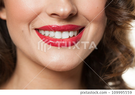 Beautiful female smile with white teeth and red lips closeup beauty portrait Beautiful female smile with white teeth and red lips closeup beauty portrait 109995559