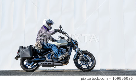 Large American motorcycle and male rider 109996086