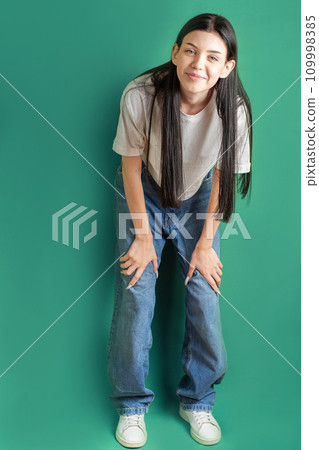 Full length portrait of a young girl in a white T-shirt and jeans. 109998385