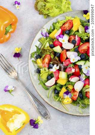Plate of vegetable salad decorated with flowers. 109999047