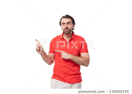young 35 year old european man with a styled haircut and beard dressed in a red t-shirt points his 110000245