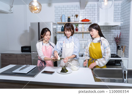 Three women making rice balls in the kitchen Three women making rice balls in the kitchen 110000354