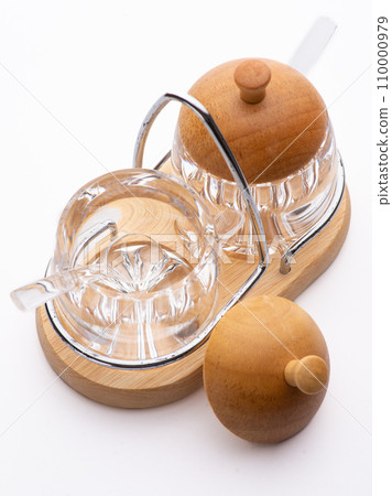 Opened glass jar with salt or sugar. Standing on wooden table Opened glass jar with salt or sugar. Standing on wooden table 110000979