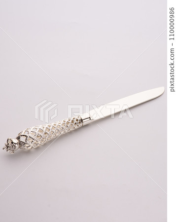 Wedding cake is set next to stainless steel utensil serving set for bride and groom to cut a slice of cake. Wedding cake is set next to stainless steel utensil serving set for bride and groom to cut a slice of cake. 110000986