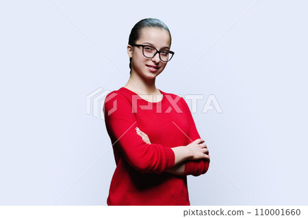 Portrait of confident smiling teenager girl in red on white background Portrait of confident smiling teenager girl in red on white background 110001660