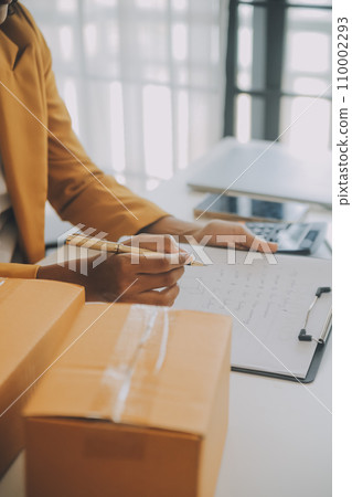 Startup SME small business entrepreneur of freelance Asian woman using a laptop with box Cheerful success happy Asian woman her hand lifts up online marketing packaging and delivery SME idea concept Startup SME small business entrepreneur of freelance Asian woman using a laptop with box Cheerful success happy Asian woman her hand lifts up online marketing packaging and delivery SME idea concept 110002293