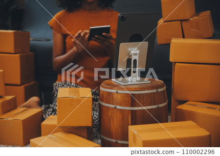 Startup SME small business entrepreneur of freelance Asian woman using a laptop with box Cheerful success happy Asian woman her hand lifts up online marketing packaging and delivery SME idea concept 110002296