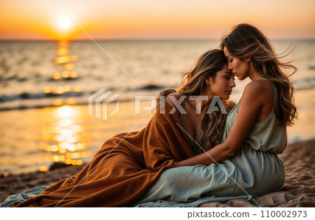 A loving lesbian couple is tenderly seated by the shore, their bodies comfortably covered by a warm blanket, as they witness the magnificent colors of the setting sun. A loving lesbian couple is tenderly seated by the shore, their bodies comfortably covered by a warm blanket, as they witness the magnificent colors of the setting sun. 110002973