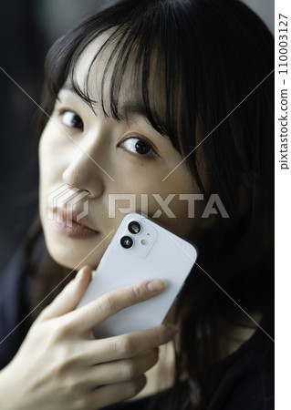 A young woman using a smartphone 110003127