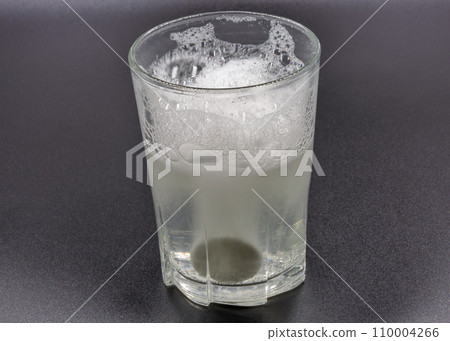 Dissolving instant effervescent tablets in a glass of water closeup 110004266