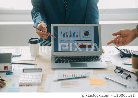 Financial analysts analyze business financial reports on a digital tablet planning investment project during a discussion at a meeting of corporate showing the results of their successful teamwork. 110005181