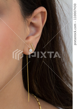 Woman wearing beautiful dangly and stud earrings with zirconia. 110007430