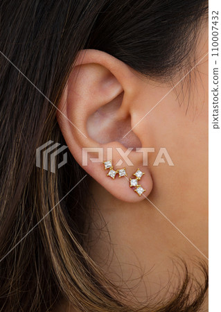 Woman wearing beautiful stud earrings with zirconia. 110007432