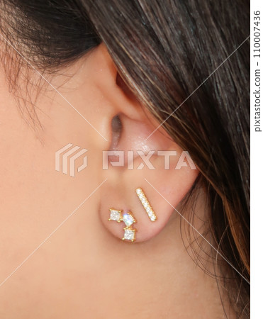 Woman wearing beautiful stud earrings with zirconia. 110007436