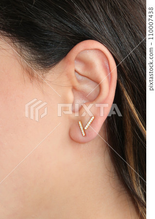 Woman wearing beautiful stud earrings with zirconia. Woman wearing beautiful stud earrings with zirconia. 110007438