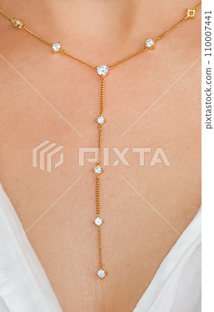 Young woman wearing a golden lariat necklace. Young woman wearing a golden lariat necklace. 110007441
