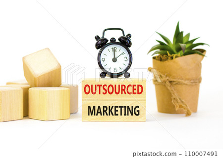 Outsourced marketing symbol. Concept words Outsourced marketing on beautiful wooden blocks. Beautiful white table white background. Black alarm clock. Business Outsourced marketing concept. Copy space 110007491