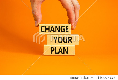 Change your plan symbol. Concept words Change your plan on wooden blocks on a beautiful orange table orange background. Businessman hand. Business, finacial and change your plan concept. Copy space. 110007532