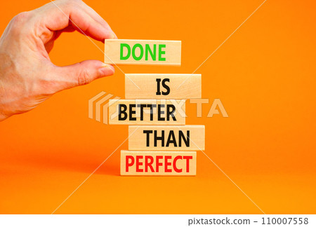 Done is better than perfect symbol. Concept words Done is better than perfect on wooden blocks. Beautiful orange background. Businessman hand. Business, done is better than perfect concept. Copy space Done is better than perfect symbol. Concept words Done is better than perfect on wooden blocks. Beautiful orange background. Businessman hand. Business, done is better than perfect concept. Copy space 110007558