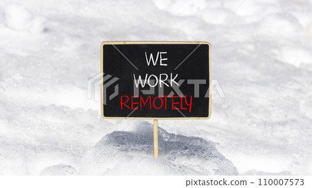 We work remotely symbol. Concept words We work remotely on beautiful black chalk blackboard. Beautiful snow background. Business we work remotely remote work concept. Copy space. 110007573