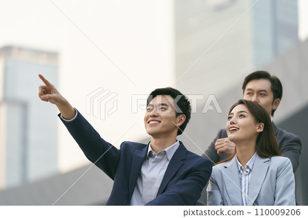 team of three asian corporate executives relaxing outdoors team of three asian corporate executives relaxing outdoors 110009206